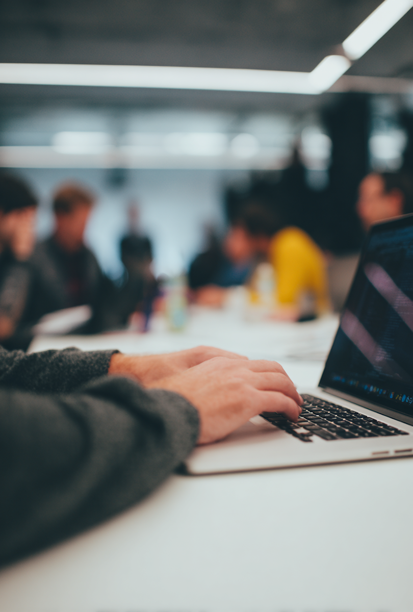 Pessoa digitando em laptop em ambiente de escritório